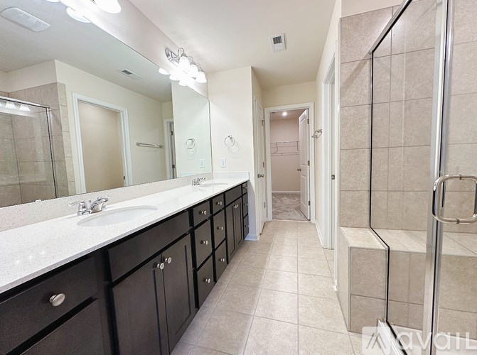 A bathroom with a sink, mirror, and tiled floor.