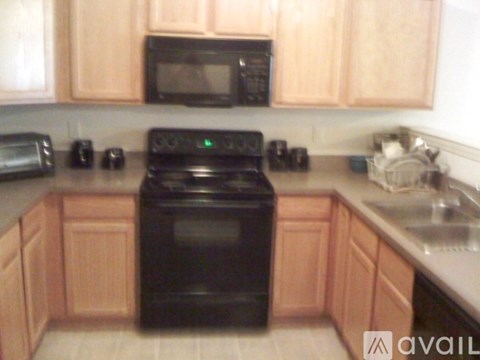 A black oven in a kitchen with wooden cabinets.