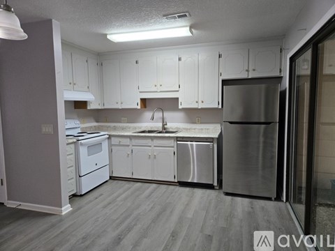 A kitchen with white cabinets and a stainless steel refrigerator.