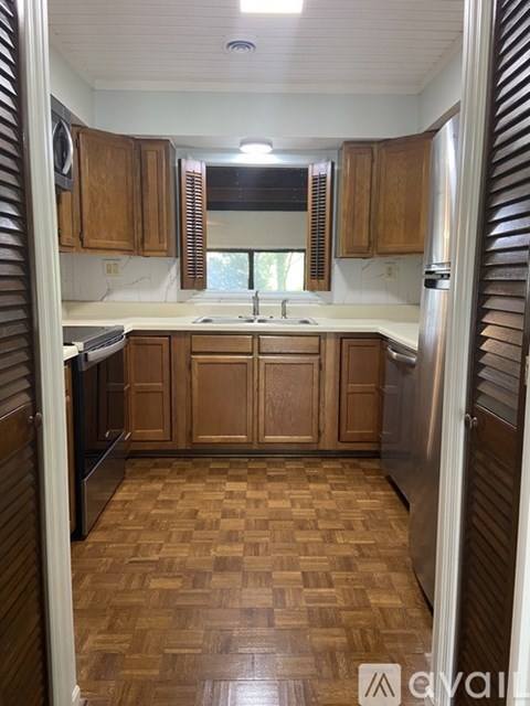 A kitchen with wooden cabinets and a checkered floor.