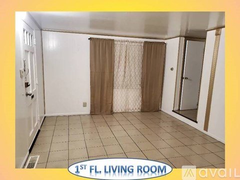 A living room with a door and a window with curtains.