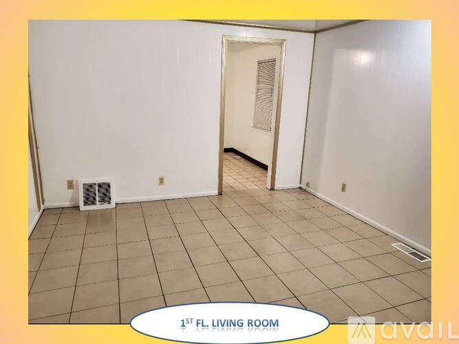 A living room with a tile floor and a doorway leading to another room.