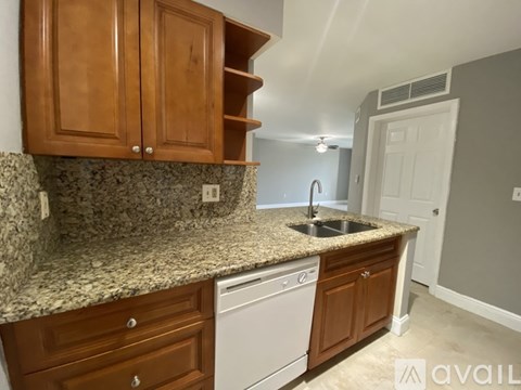 A kitchen with wooden cabinets and granite countertops.