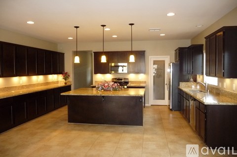 A modern kitchen with dark brown cabinets and a central island.