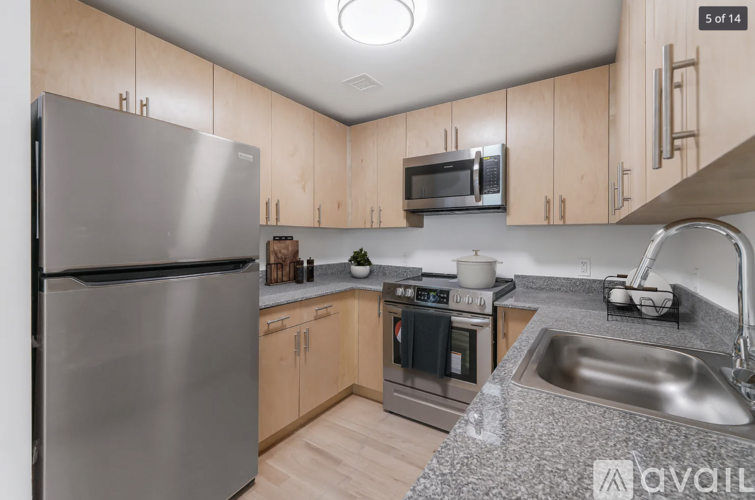 A kitchen with a stainless steel refrigerator, microwave, oven, and sink.