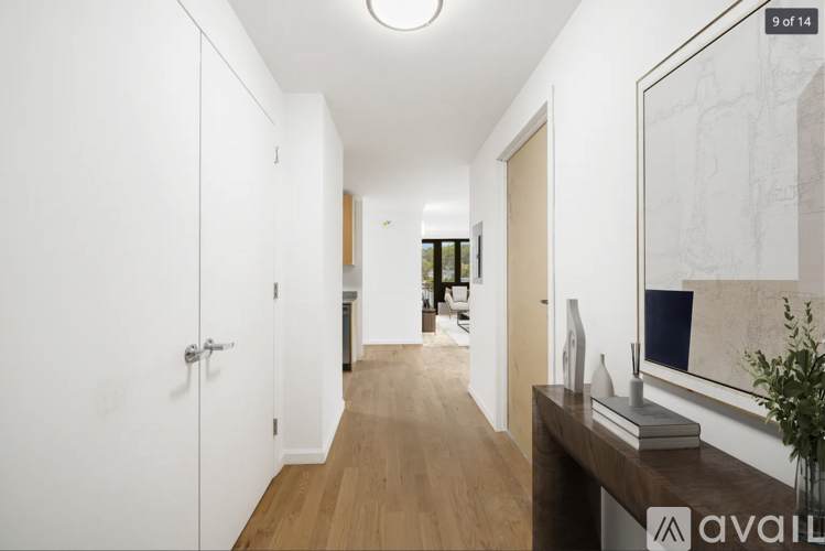 A hallway with a wooden floor and white walls.
