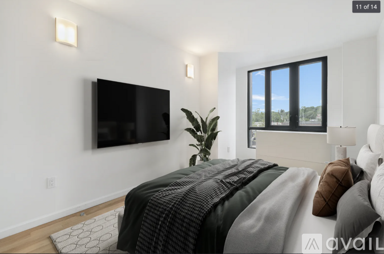 A bedroom with a large bed and a flat screen TV mounted on the wall.