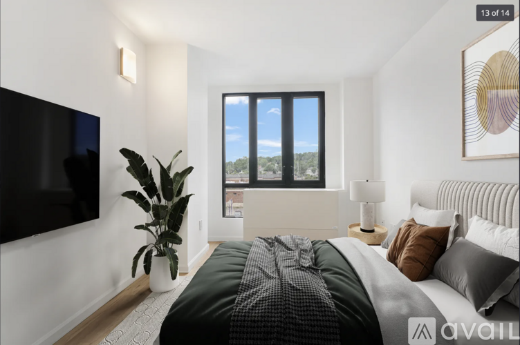 A bedroom with a large bed and a flat screen TV mounted on the wall.