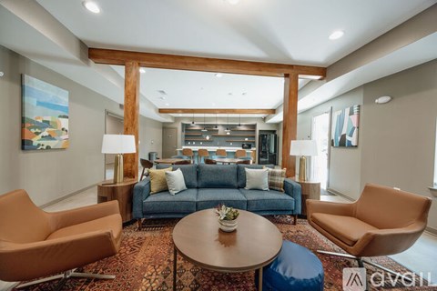 A living room with a blue couch and two orange chairs.