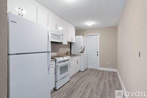 A kitchen with white appliances and cabinets.