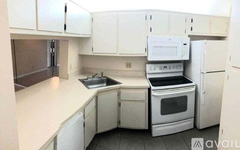 A kitchen with white cabinets and appliances.