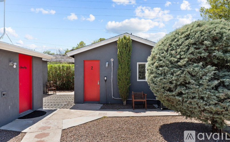 A modern house with red doors and a grey exterior.