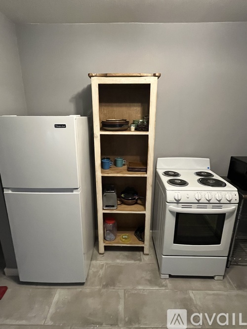 A white refrigerator and stove are in a kitchen.