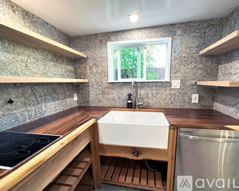 A kitchen with a stove top oven and a white sink.
