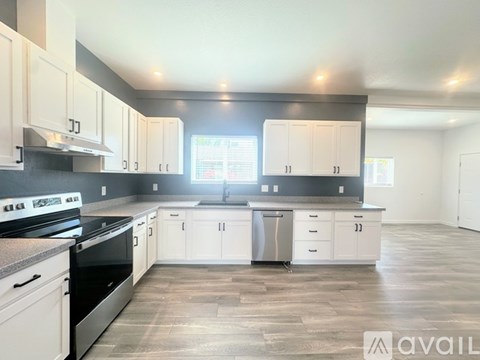 A kitchen with white cabinets and a black stove top oven.