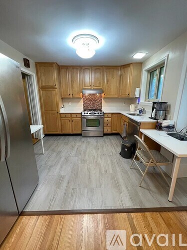 A kitchen with wooden cabinets and a refrigerator.