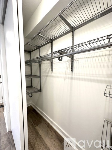 A white wall with a metal shelf on it.