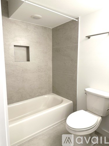 A white toilet sits next to a bathtub in a bathroom.