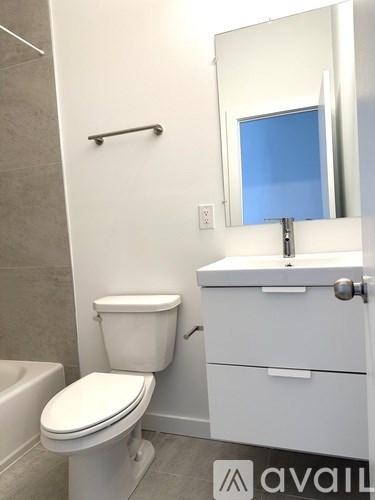 A white toilet sits next to a white sink in a bathroom.