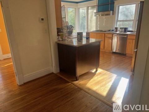 A kitchen with wooden floors and a large island in the middle.