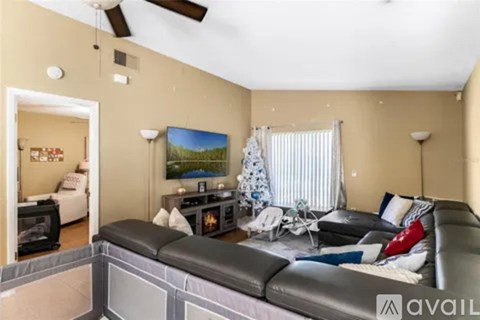 A living room with a black couch and a television.