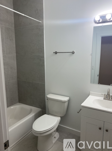 A white toilet sits next to a bathtub in a bathroom.
