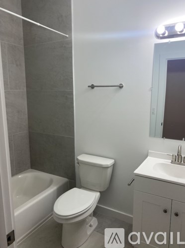 A white toilet sits next to a bathtub in a bathroom.