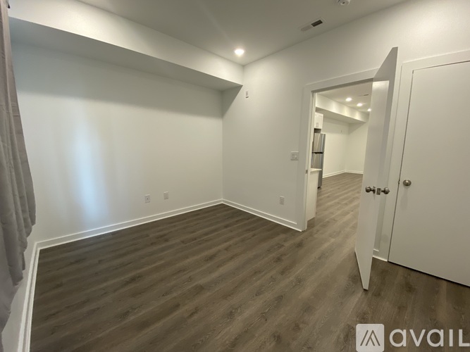 A room with wooden flooring and white walls.