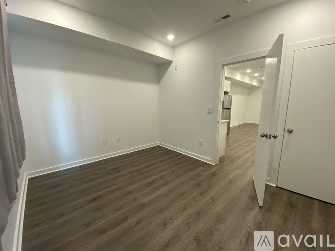 A room with wooden flooring and white walls.