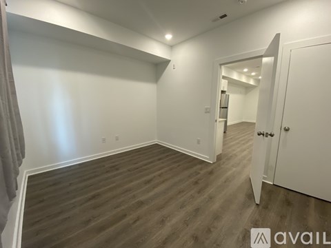 A room with wooden flooring and white walls.