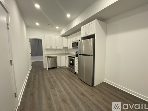 A kitchen with white cabinets and a refrigerator.