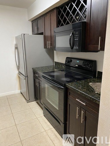 A kitchen with a black stove top oven and a black microwave above it.
