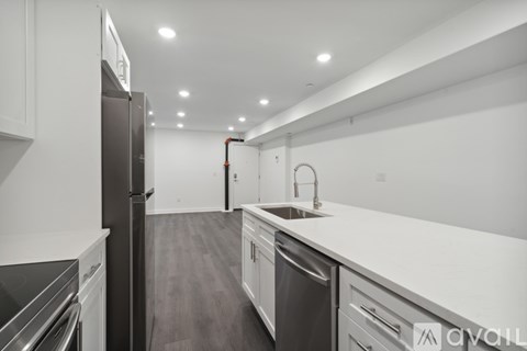A modern kitchen with stainless steel appliances and white cabinetry.