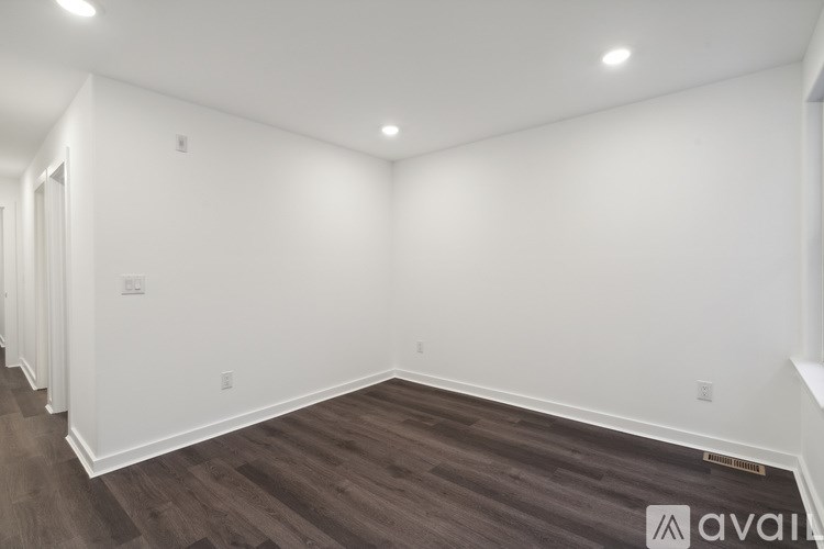 A room with wooden flooring and white walls.
