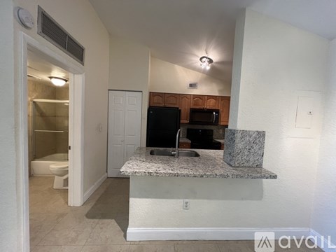 A kitchen area with a granite countertop and a microwave above it.