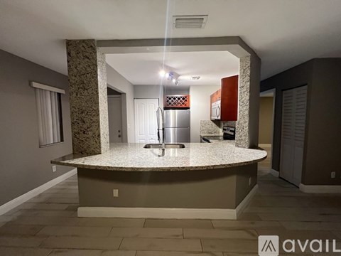 A kitchen with a granite countertop and a refrigerator.
