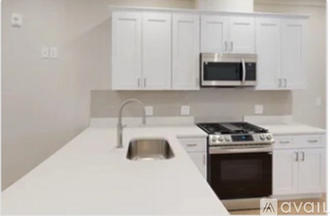 A kitchen with white cabinets and appliances.