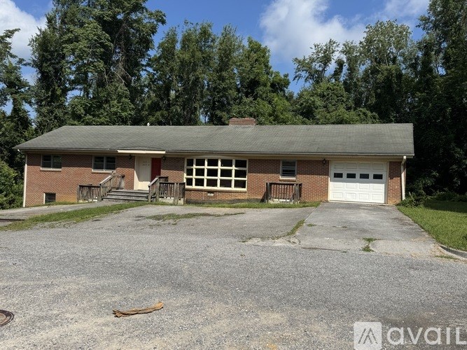 A two-story house with a garage and a driveway in front.