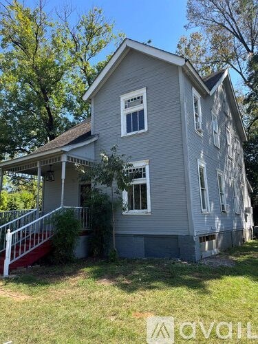 A house with a grey siding and a red staircase.