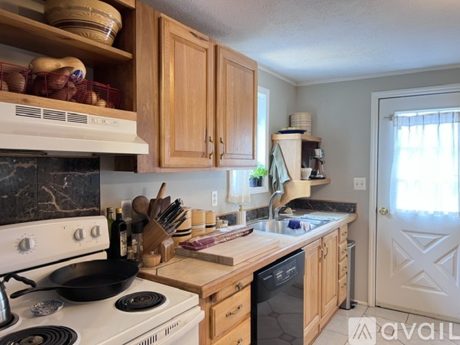 A kitchen with wooden cabinets and a white stove top oven.