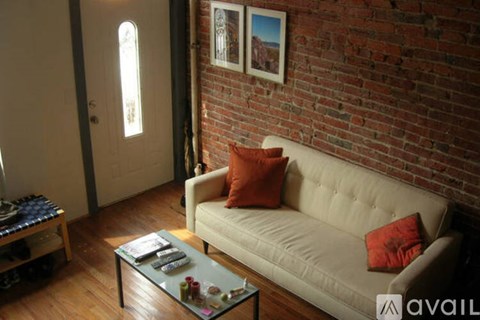 A living room with a white couch and a glass coffee table.