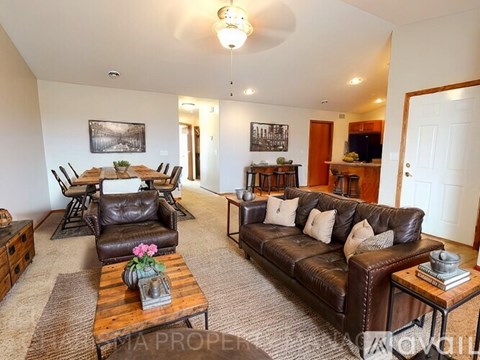 A living room with a brown leather couch and a wooden coffee table.