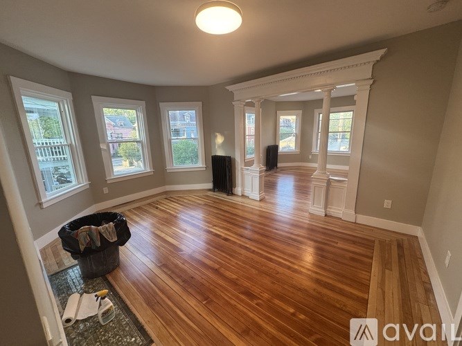 A room with wooden floors and a large window.