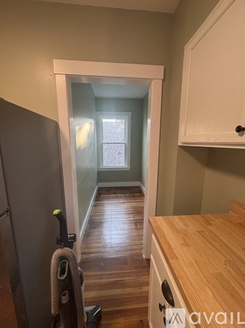 A kitchen with a wooden counter and a vacuum cleaner.