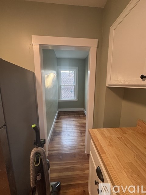A kitchen with a wooden counter and a vacuum cleaner.