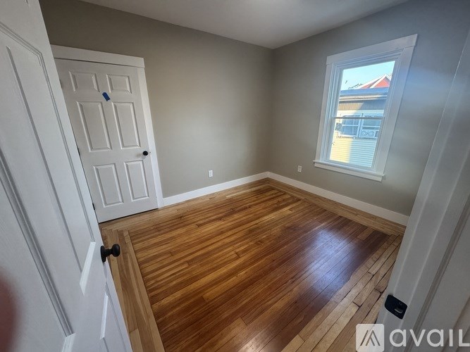 A room with wooden flooring and a white door.