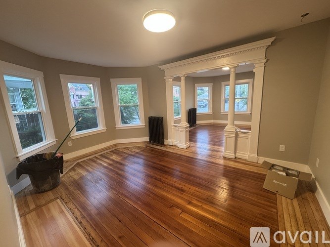 A room with wooden floors and white columns.