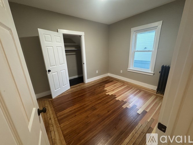 A room with a wooden floor and a white door.