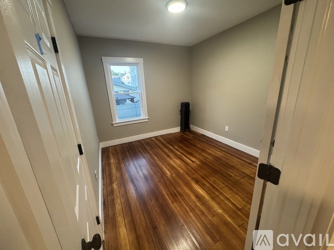A room with wooden floors and a window.