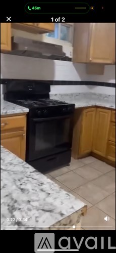 A kitchen with a black oven and wooden cabinets.
